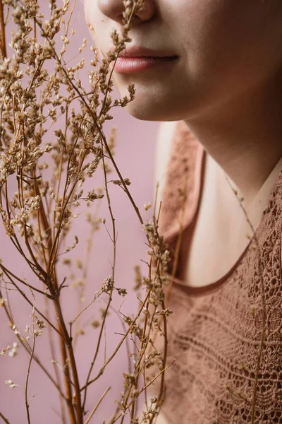 Безликий крупним планом молода жінка тримає суху траву перед її губами, вибірковий фокус — стокове фото