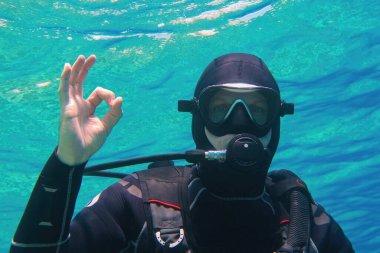Man scuba diver underwater showing signal OK clipart