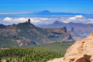 Gran Canaria Adası 'nın panoramik manzarası. Ünlü kaya Roque Nublo ve ada Tenerife en yüksek İspanyol volkanı Pico del Teide ufukta.