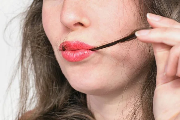 Saçları kırmızı dudaklı güzel bir kadın. Trikofaji - Trikotilomani ile ilişkili saç yeme saplantısı (saç çekme))