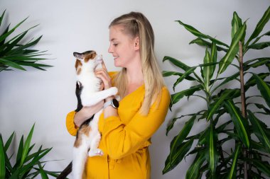 young woman carrying her cat on arms