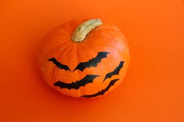 Turuncu arka planda izole edilmiş Cadılar Bayramı kabağı