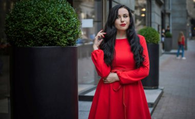 Koyu renk saçlı ve soluk tenli Avrupalı bir kadın, şehirde klasik tarzda, şık bir açık hava portresi.