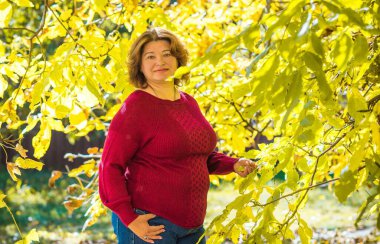 Artı, Avrupalı ya da Amerikalı yetişkin bir kadın parkta, hayatın tadını çıkarıyor, yürüyor. İnsanların hayatı XI boyutunda, mutlu, güzel, güzel bir kadın. Aşırı kilolu kavramı