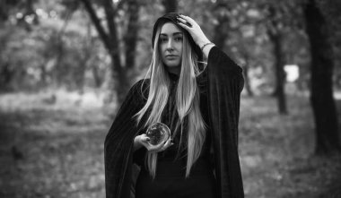 Karanlık mistik orman, Cadılar Bayramı parti fikirleri, bayanlar için kıyafetler, sihirbazlık kavramı ve sihir.