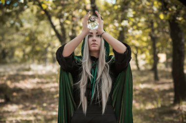 Karanlık mistik orman, Cadılar Bayramı parti fikirleri, bayanlar için kıyafetler, sihirbazlık kavramı ve sihir.