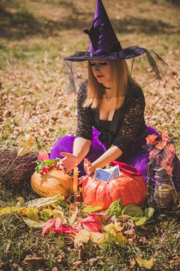 Cadılar Bayramı partisi konsepti, siyah elbiseli gizemli kız. Güzel, genç, karanlık cadı kadın. Cadılar Bayramı kutlamaları için ilham, fikirler ve basit detaylar.