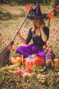 Cadılar Bayramı partisi konsepti, siyah elbiseli gizemli kız. Güzel, genç, karanlık cadı kadın. Cadılar Bayramı kutlamaları için ilham, fikirler ve basit detaylar.