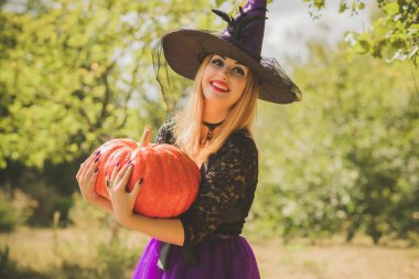 Cadılar Bayramı partisi konsepti, siyah elbiseli gizemli kız. Güzel, genç, karanlık cadı kadın. Cadılar Bayramı kutlamaları için ilham, fikirler ve basit detaylar.