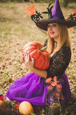 Cadılar Bayramı partisi konsepti, siyah elbiseli gizemli kız. Güzel, genç, karanlık cadı kadın. Cadılar Bayramı kutlamaları için ilham, fikirler ve basit detaylar.