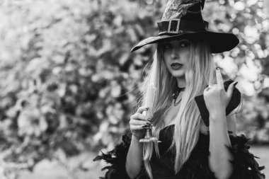 Cadılar Bayramı partisi konsepti, siyah elbiseli gizemli kız. Güzel, genç, karanlık cadı kadın. Cadılar Bayramı kutlamaları için ilham, fikirler ve basit detaylar.