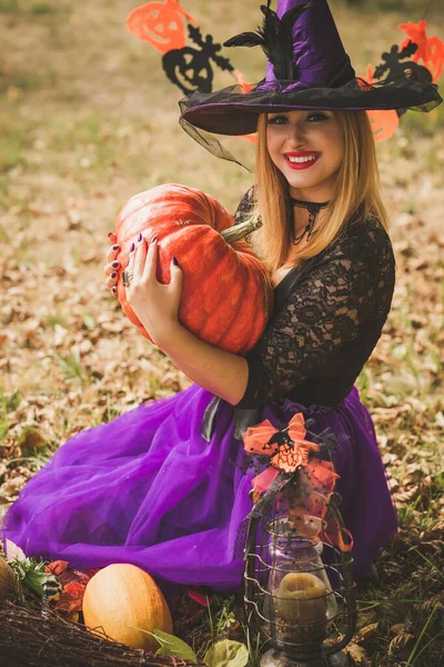 Cadılar Bayramı partisi konsepti, siyah elbiseli gizemli kız. Güzel, genç, karanlık cadı kadın. Cadılar Bayramı kutlamaları için ilham, fikirler ve basit detaylar.