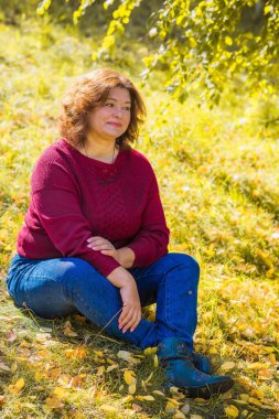 Çekici ve olgun bir kadının portresi. Güneşli bir sonbahar gününde gündelik tarzda yürüyüp bir şeyler düşünüyor. 40-50 yıl sonra kadın hayatı