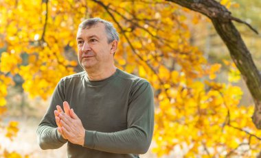 Olgun bir Avrupalı adam, güzel bir ruh hali, sonbahar parkında açık hava portresi. 50 yıl sonra yaşam konsepti