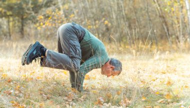 Yaşlı adam doğada yoga yapıyor. Yeni dünyanın insanları, zamanı değiştiriyor.