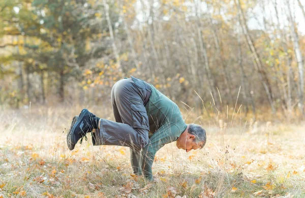Older man practice yoga at nature. People of new world, changing time