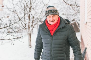Kış karlı gününde mutlu kıdemli adam eğleniyor. Emeklilerin hayatı, pozitif yaşam tarzı.