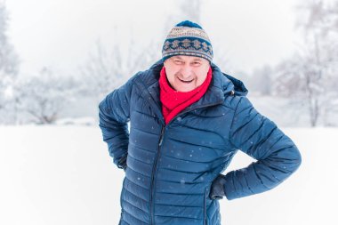 Kış karlı gününde mutlu kıdemli adam eğleniyor. Emeklilerin hayatı, pozitif yaşam tarzı.