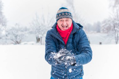 Kış karlı gününde mutlu kıdemli adam eğleniyor. Emeklilerin hayatı, pozitif yaşam tarzı.