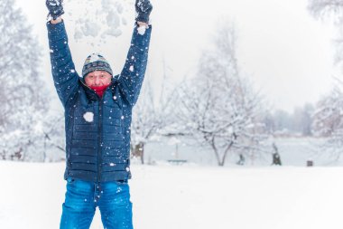 Kış karlı gününde mutlu kıdemli adam eğleniyor. Emeklilerin hayatı, pozitif yaşam tarzı.