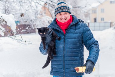 Kış karlı gününde mutlu kıdemli adam eğleniyor. Emeklilerin hayatı, pozitif yaşam tarzı.