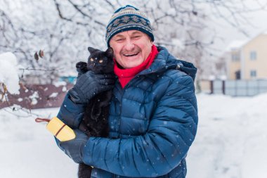Kış karlı gününde mutlu kıdemli adam eğleniyor. Emeklilerin hayatı, pozitif yaşam tarzı.
