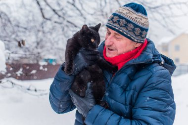Kış karlı gününde mutlu kıdemli adam eğleniyor. Emeklilerin hayatı, pozitif yaşam tarzı.