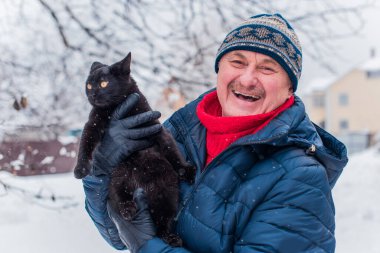 Kış karlı gününde mutlu kıdemli adam eğleniyor. Emeklilerin hayatı, pozitif yaşam tarzı.