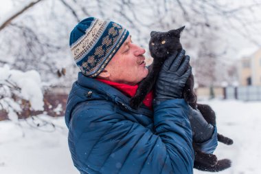 Kış karlı gününde mutlu kıdemli adam eğleniyor. Emeklilerin hayatı, pozitif yaşam tarzı.
