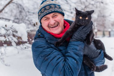 Kış karlı gününde mutlu kıdemli adam eğleniyor. Emeklilerin hayatı, pozitif yaşam tarzı.