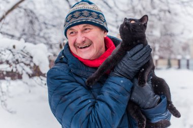 Kış karlı gününde mutlu kıdemli adam eğleniyor. Emeklilerin hayatı, pozitif yaşam tarzı.