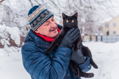 Kış karlı gününde mutlu kıdemli adam eğleniyor. Emeklilerin hayatı, pozitif yaşam tarzı.
