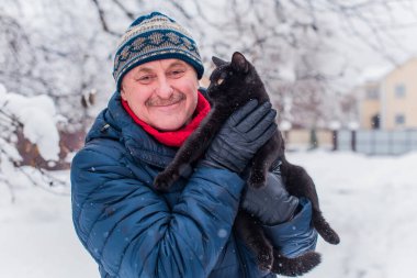 Kış karlı gününde mutlu kıdemli adam eğleniyor. Emeklilerin hayatı, pozitif yaşam tarzı.