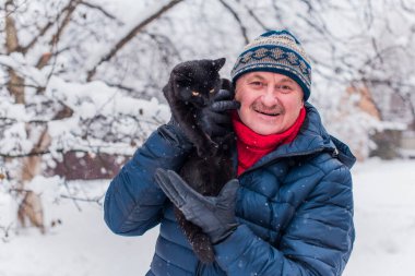 Kış karlı gününde mutlu kıdemli adam eğleniyor. Emeklilerin hayatı, pozitif yaşam tarzı.