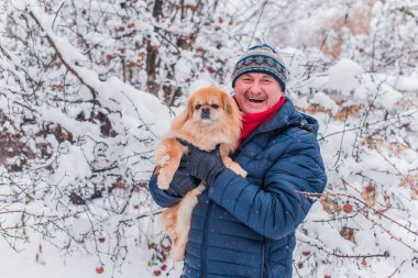 Kış karlı gününde mutlu kıdemli adam eğleniyor. Emeklilerin hayatı, pozitif yaşam tarzı.