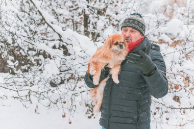 Kış karlı gününde mutlu kıdemli adam eğleniyor. Emeklilerin hayatı, pozitif yaşam tarzı.