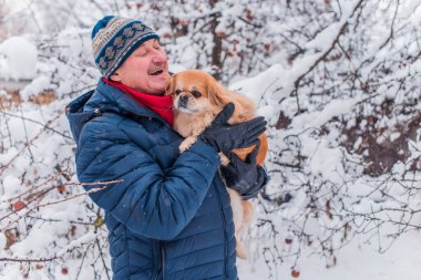 Kış karlı gününde mutlu kıdemli adam eğleniyor. Emeklilerin hayatı, pozitif yaşam tarzı.