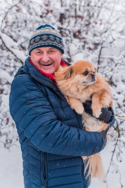 Kış karlı gününde mutlu kıdemli adam eğleniyor. Emeklilerin hayatı, pozitif yaşam tarzı.