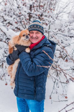 Kış karlı gününde mutlu kıdemli adam eğleniyor. Emeklilerin hayatı, pozitif yaşam tarzı.