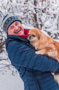 Kış karlı gününde mutlu kıdemli adam eğleniyor. Emeklilerin hayatı, pozitif yaşam tarzı.