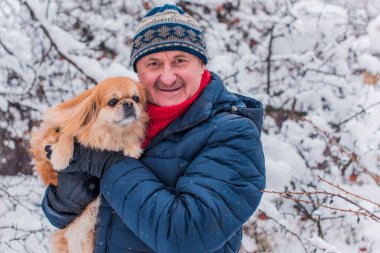 Kış karlı gününde mutlu kıdemli adam eğleniyor. Emeklilerin hayatı, pozitif yaşam tarzı.