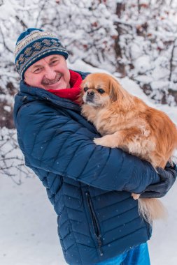 Kış karlı gününde mutlu kıdemli adam eğleniyor. Emeklilerin hayatı, pozitif yaşam tarzı.