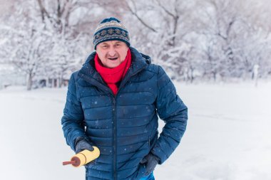 Kış karlı gününde mutlu kıdemli adam eğleniyor. Emeklilerin hayatı, pozitif yaşam tarzı.