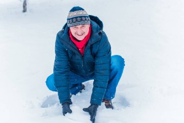 Kış karlı gününde mutlu kıdemli adam eğleniyor. Emeklilerin hayatı, pozitif yaşam tarzı.