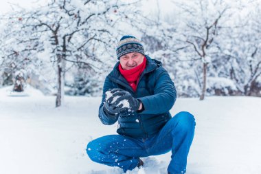 Kış karlı gününde mutlu kıdemli adam eğleniyor. Emeklilerin hayatı, pozitif yaşam tarzı.