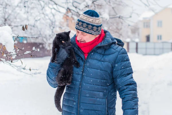 Kış karlı gününde mutlu kıdemli adam eğleniyor. Emeklilerin hayatı, pozitif yaşam tarzı.