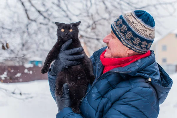 Kış karlı gününde mutlu kıdemli adam eğleniyor. Emeklilerin hayatı, pozitif yaşam tarzı.