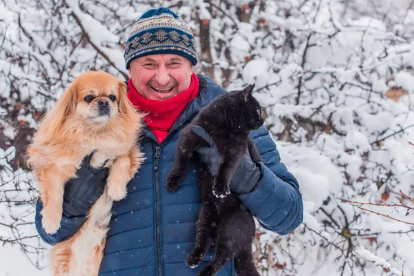 Kış karlı gününde mutlu kıdemli adam eğleniyor. Emeklilerin hayatı, pozitif yaşam tarzı.
