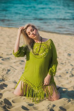 Haki keten elbiseli güzel ve iri kadın doğada dinleniyor, kadın modası konsepti. Leydi XI plajda eğleniyor.