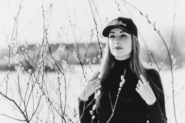 Kadınlar siyah balıkçı yaka, kot pantolon ve beyzbol şapkası giyer. Kum çölündeki bir kız. Modern görünüş modası, moda ve giysi konsepti